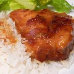 Chicken breast topped with apricot sauce, served with rice and a side salad.