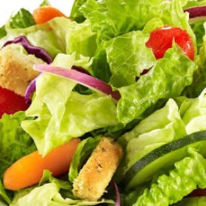 Fresh garden salad with crisp lettuce, cucumber slices, red onion, carrots, tomatoes, and seasoned croutons.