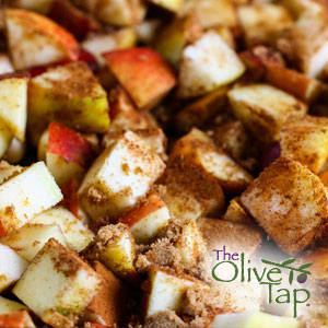 Close-up of baked cinnamon apples featuring diced red and green apple pieces coated in cinnamon and brown sugar.