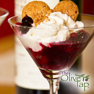 Martini glass filled with berry mixture and topped with whipped mascarpone cheese, blueberries, and biscotti.