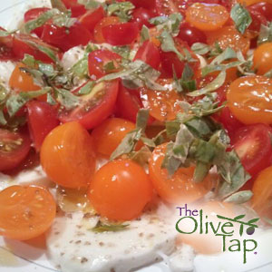 Halved cherry tomatoes on sliced mozzarella cheese and topped with chopped fresh basil.