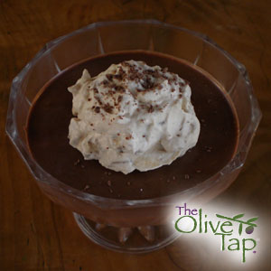 Chocolate mousse topped with whipped cream and chocolate shavings, served in a glass dessert dish.