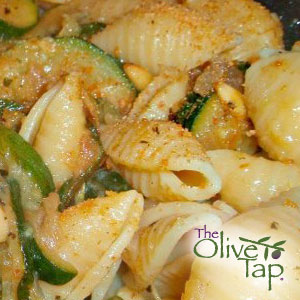 Shell pasta tossed with sliced zucchini and fresh basil in a light sauce.