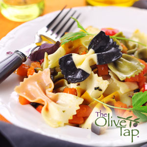 A bowl of colorful farfalle pasta garnished with fresh parsley in a white bowl with a fork.
