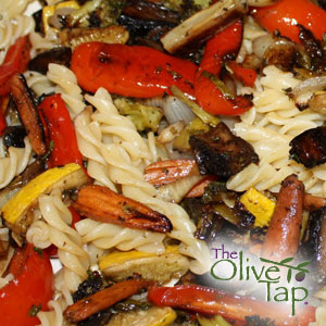 A mixture of fusilli with sliced zucchini, cherry tomatoes, onions, and sliced black olives.