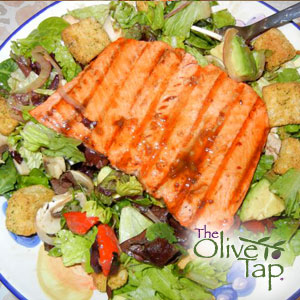 Grilled salmon fillet on a salad with croutons and avocado, drizzled with a hoisin tangerine glaze.
