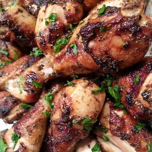 Chicken drumsticks with a garlic herb balsamic glaze, garnished with chopped parsley.