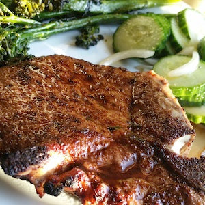 Balsamic glazed porkchop served with a fresh cucumber salad and broccolini.