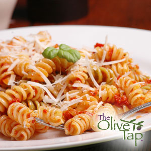 Rotini pasta tossed in a light tomato sauce, topped with grated Parmesan cheese and fresh basil, served on a white plate.