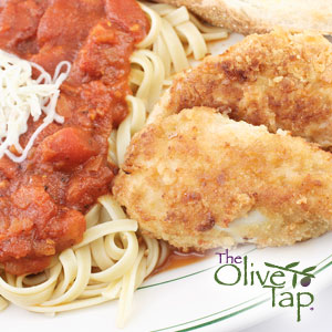 Breaded chicken cutlets served over linguine pasta with chunky tomato sauce and grated Parmesan cheese, accompanied by a slice of crusty bread.