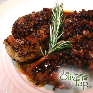Braised balsamic chicken topped with a rich balsamic glaze and garnished with a fresh rosemary sprig, served on a white plate.