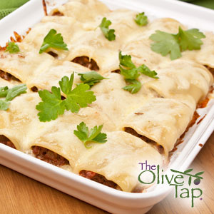 Baked stuffed pasta shells filled with a savory tuna mixture, topped with melted cheese and garnished with fresh parsley, served in a white baking dish.