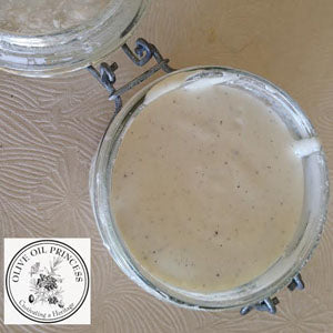 Creamy white marshmallow creme served in an open glass jar with a hinged lid.