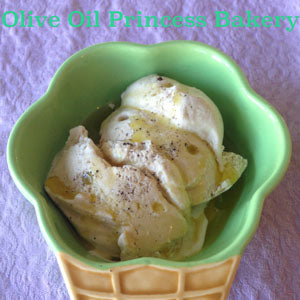 Scoops of vanilla ice cream drizzled with olive oil and sprinkled with sea salt, served in a green waffle cone-shaped bowl.