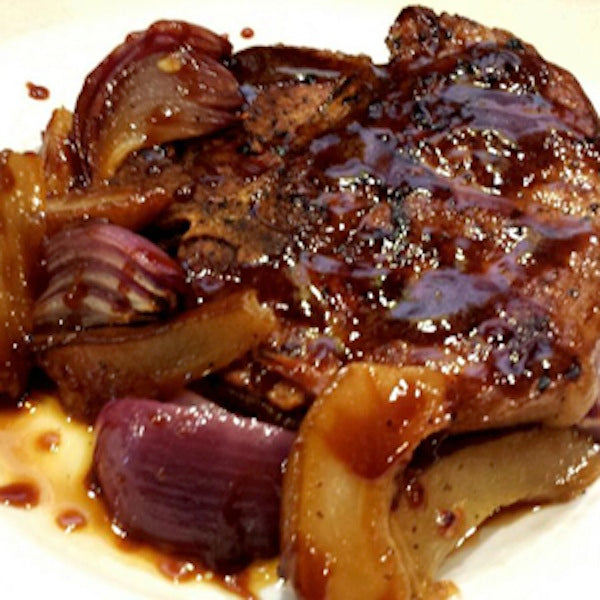 Braised pork chop with pears and onions, drizzled with a balsamic glaze reduction.