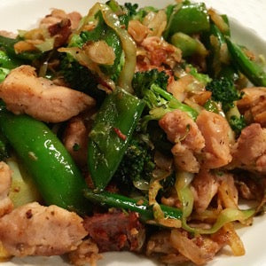 Chicken and vegetable stir-fry made with tender chicken pieces, broccoli, snap peas, cabbage, and onions, sautéed in a savory sauce.