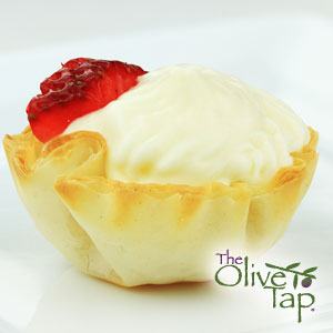 Baked phyllo dough cup filled with a whipped cheese filling and garnished with a fresh strawberry slice.