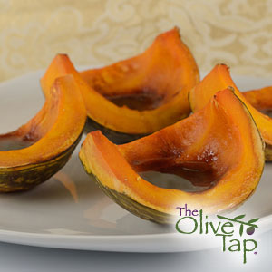 Roasted squash wedges glazed with cranberry balsamic vinegar and arranged on a white plate.