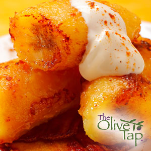 Close-up of caramelized banana slices topped with yogurt and a sprinkle of cinnamon sugar.