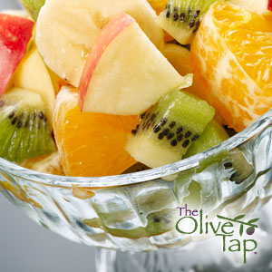 A close-up of a fruit salad with apples, bananas, kiwi, and oranges, served in a glass bowl.