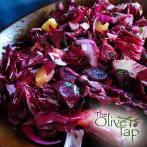 Radicchio salad with orange segments, garnished with chopped tarragon, served in a bowl.