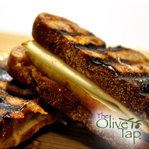 Grilled apple and cheese panini made with toasted artisan bread, layered with melted cheese and sliced apples, showing crisp grill marks and a golden-brown crust.