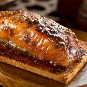 A smoked salmon fillet covered in a balsamic mustard glaze, served on a cedar plank.