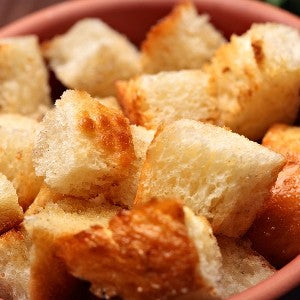 A close-up of golden-brown toasted bread cubes piled in a bowl.