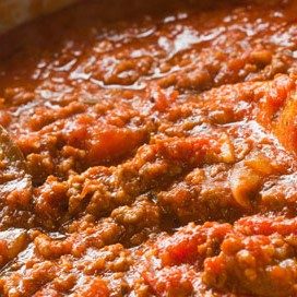 Close-up of a rich and hearty Bolognese sauce simmered with ground meat, tomatoes, and herbs, showcasing its thick, chunky texture.