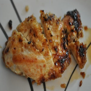 Juicy brown sugar glazed chicken pieces with caramelized edges and a golden-brown finish, served on a white plate.