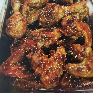 Baked chicken pieces covered with a Korean sauce and sesame seeds,