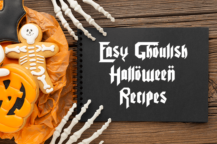 A Halloween-themed recipe graphic featuring decorated pumpkin and skeleton cookies, skeleton hands, and the text "Easy Ghoulish Halloween Recipes" on a black notebook.