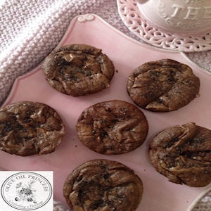 Six chocolate olive oil cakes arranged on a pink serving tray.