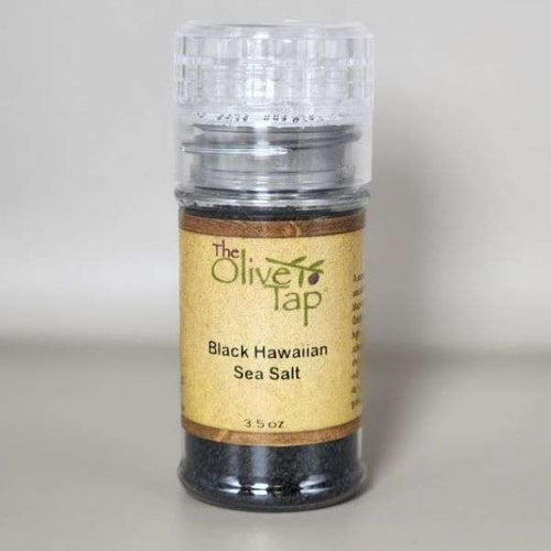 Black Hawaiian Sea Salt in a grinder jar from The Olive Tap with The Olive Tap logo and olive branch against a neutral background.
