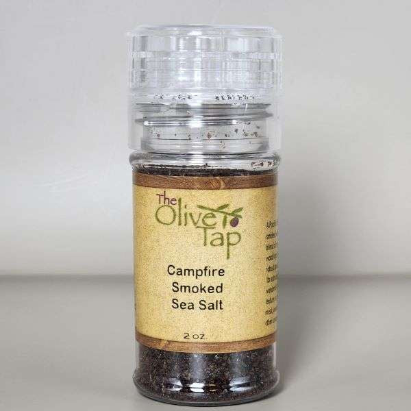 Campfire Smoked Sea Salt in a grinder jar from The Olive Tap with The Olive Tap logo and olive branch against a neutral background.