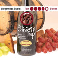 A bottle of The Olive Tap Chocolate Covered Cherries Balsamic Vinegar with a picture of chocolate covered cherries, surrounded by grapes in front of a wooden barrel, and a sweetness scale indicating a four on a light background.