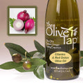 A bottle of Cilantro & Red Onion Olive Oil from The Olive Tap next to olives and leaves with an inset showing red onions and cilantro on a light background.