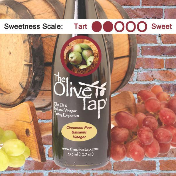 A bottle of Cinnamon Pear Balsamic Vinegar from The Olive Tap with a picture of ground cinnamon and pears, surrounded by grapes in front of a wooden barrel, and a sweetness scale indicating a two on a light background.