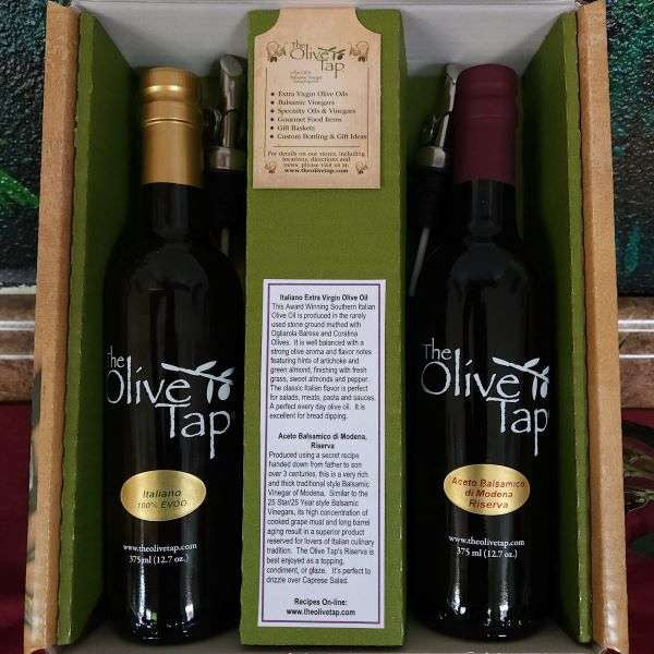 The Olive Tap's Classic Italian Gift Box: one bottle of olive oil and one bottle of balsamic vinegar in a box, divided by a piece of cardboard with a description of each product, and metal pour spouts sit next to each bottle.
