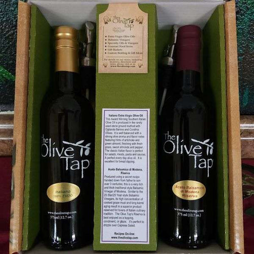 The Olive Tap's Classic Italian Gift Box: one bottle of olive oil and one bottle of balsamic vinegar in a box, divided by a piece of cardboard with a description of each product, and metal pour spouts sit next to each bottle.