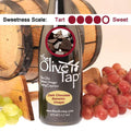 Bottle of The Olive Tap Dark Chocolate Balsamic Vinegar with grapes in front of a wooden barrel indicating a sweetness scale of four.