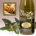 Bottle of The Olive Tap French Roasted Walnut Oil next to olives and leaves with an inset showing fresh walnuts.