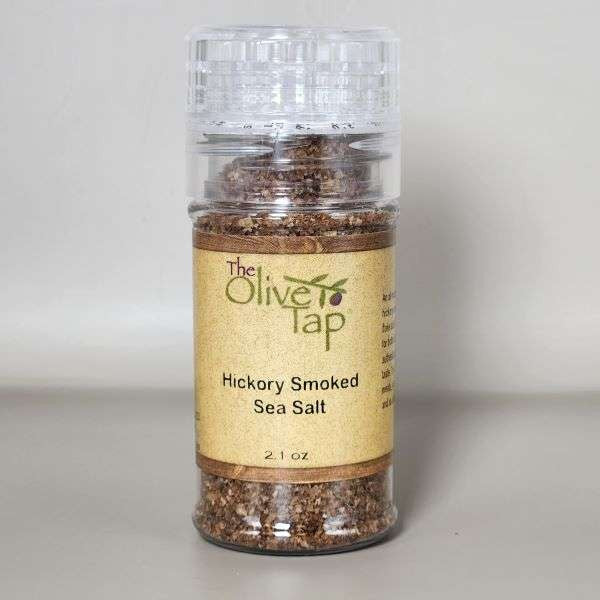 Hickory Smoked Sea Salt in grinder jar from The Olive Tap with The Olive Tap logo and olive branch against a neutral background.