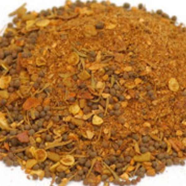 Jamaican Jerk Seasoning from The Olive Tap: a pile of red, brown, and tan spices against a white background.