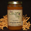 A jar of Pumpkin Butter from The Olive Tap, surrounded by decorative orange crinkle paper.