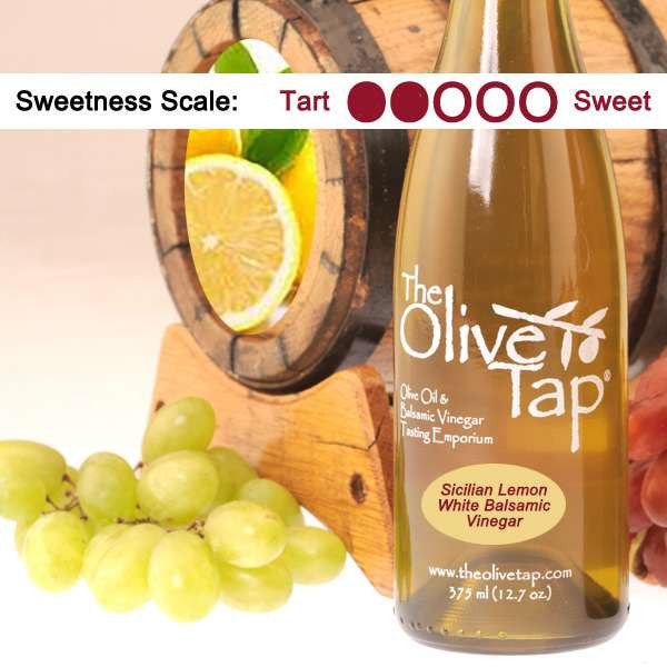 Sicilian Lemon White Balsamic Vinegar from The Olive Tap surrounded by grapes in front of a wooden barrel with a picture of lemons in it, and a sweetness scale indicating a two.