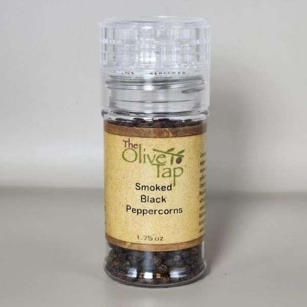 Smoked Black Peppercorns in Grinder Jar from The Olive Tap with The Olive Tap logo with an olive branch, against a white backdrop.