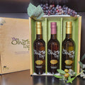 Some Like It Hot Trio Gift Box from The Olive Tap: A decorative Olive Tap box with three bottles inside of olive oils and vinegar, surrounded by decorative grapes and olives.