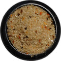 Spicy Garlic Pepper Sea Salt from The Olive Tap:  Tan-colored pebble-sized chunks of sea salt with orange and brown flakes in a black bowl and a white background.