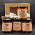 Collection of tapenade jars from The Olive Tap with a spreader and gold gift box.